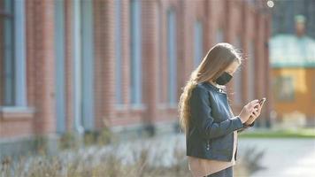 meisje vervelend een masker beschermen tegen coronavirus en greep video