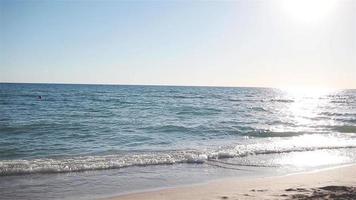 idyllisch tropisch strand met wit zand, turkoois zee water en mooi kleurrijk lucht video