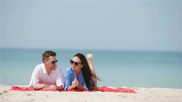 familia joven de dos en la playa blanca durante las vacaciones de verano video