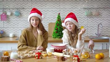 liten flickor framställning jul pepparkaka hus på öppen spis i dekorerad levande rum. video