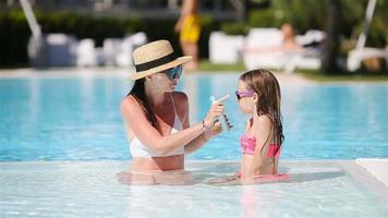 Young mother applying sun cream to daughter nose video