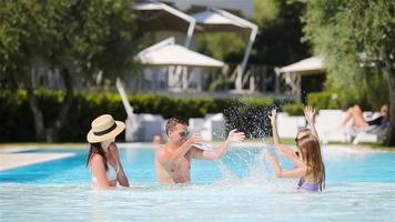 familia feliz de cuatro en la piscina al aire libre video