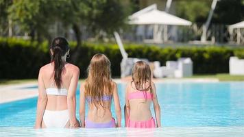 Mother and two kids enjoying summer vacation in luxury swimming pool video