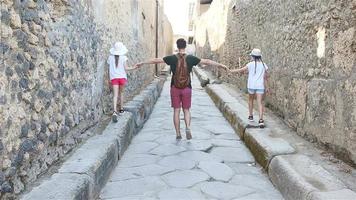 Father and kids in ruins of ancient city of Pompeii near volcano Vizuvius, Pompei, Naples, Italy video