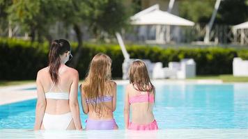 mãe e dois filhos aproveitando as férias de verão na piscina de luxo video