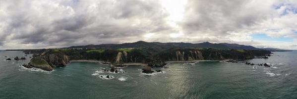 silencio playa, arena plateada ensenada Respaldados por un natural rock anfiteatro en Asturias, España. foto