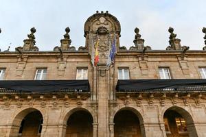 City Hall building with flags on the facade at the Plaza de Espana square in the Ribadeo city center, Lugo, Galicia, Spain. photo