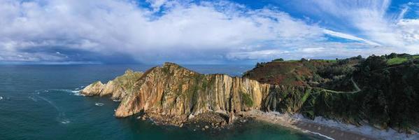 Silence beach, silver-sandy cove backed by a natural rock amphitheatre in Asturias, Spain. photo