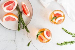 Refreshing grapefruit cocktail with rosemary in glasses on the table. homemade drink. Top view. photo