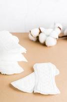 limpiar desechable sanitario almohadillas y un rama de algodón en un beige antecedentes. De las mujeres salud y comodidad concepto foto