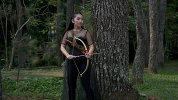 Indonesische Frauen schießen einen Pfeil vom Bogen auf den Feind, den sie im Dschungel verfolgt video