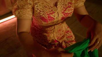 Indonesian woman wearing a green scarf on her belly with an orange dress on her body video