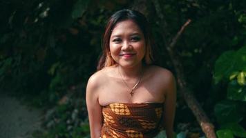 An Asian woman wakes up from her sleep while enjoying the beach atmosphere on an island by lying on a tree trunk video