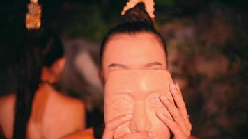 a beautiful Asian woman is wearing a bamboo mask for a dance performance at a festival held in the village video