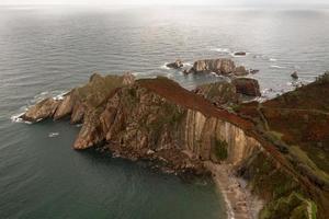 silencio playa, arena plateada ensenada Respaldados por un natural rock anfiteatro en Asturias, España. foto