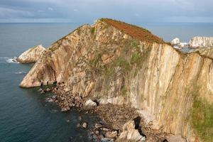 Silence beach, silver-sandy cove backed by a natural rock amphitheatre in Asturias, Spain. photo