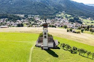 St. Valentin  Kastelruth  Village Church in the summer in the Dolomite Alps. Amazing landscape with small chapel on sunny meadow and Petz peak at Kastelruth commune. Dolomites, South Tyrol, Italy photo