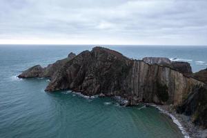 Silence beach, silver-sandy cove backed by a natural rock amphitheatre in Asturias, Spain. photo