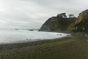 The Campiecho beach is located in Asturias, Spain on a cloudy day. photo