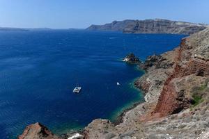 Charming view Oia village on Santorini island, Greece. Traditional famous blue dome church over the Caldera in Aegean sea. Traditional blue and white Cyclades architecture. photo