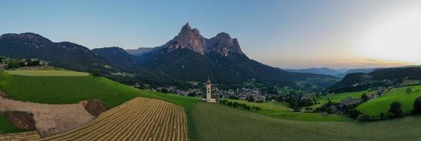 St. Valentin  Kastelruth  Village Church in the summer in the Dolomite Alps. Amazing landscape with small chapel on sunny meadow and Petz peak at Kastelruth commune. Dolomites, South Tyrol, Italy photo