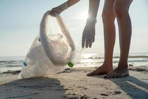 Save water. Volunteer pick up trash garbage at the beach and plastic bottles are difficult decompose prevent harm aquatic life. Earth, Environment, Greening planet, reduce global warming, Save world photo