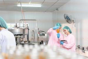 A quality supervisor or food or beverages technician discuss about process control of food and drugs before send product to the customer. Production leader recheck ingredient and productivity. photo