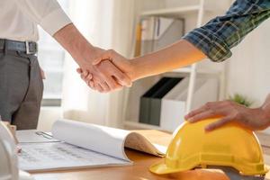 Construction worker team hands shaking greeting start up plan new project contract in office center at construction site, industry ,architecture, partner, teamwork, agreement, property, contacts. photo