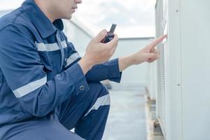 maintenance engineer works on the roof of factory. contractor inspect compressor system and plans installation of air condition systems in construction. technology, online checking photo