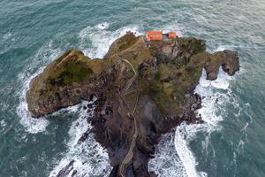 Green rocky mountains and coastline scenery, San Juan de Gaztelugatxe, Spain photo