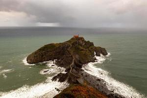 Green rocky mountains and coastline scenery, San Juan de Gaztelugatxe, Spain photo