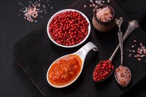Red adjika sauce or ketchup with spices and herbs photo