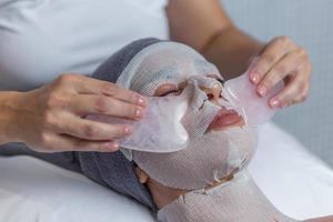 cerca arriba ver de cara de mujer recepción gua sha facial masaje tratamiento por cosmetólogo en salud spa foto