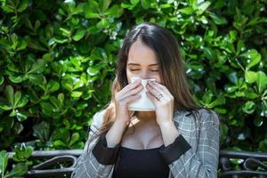 Woman with pollen allergy sneezing with closed eyes photo