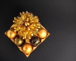 Pascua de Resurrección huevos pintado en oro y negro. mentira en un texturizado estar con un dorado flor, en un oscuro, no agudo antecedentes foto