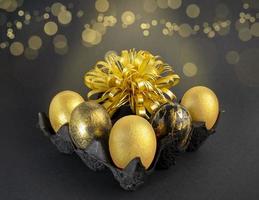 elegante concepto de Pascua de Resurrección dorado huevos. Pascua de Resurrección dorado huevos en un oscuro antecedentes con Bokeh. tarjeta postal con Copiar espacio foto