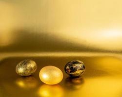 Easter eggs painted in gold and black on a glittering background for the holiday of bright easter photo