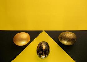 Bright Easter. Eggs are black and gold on the background of a geometric pattern. photo