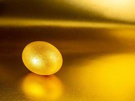 dorado huevo en un dorado, reluciente antecedentes para el fiesta de brillante Pascua de Resurrección foto