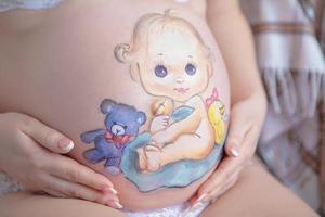 encantador dibujo en el estómago de un embarazada mujer foto