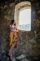 Beautiful lady posing among antique ruins photo