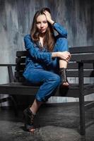 Cute young woman dressed in denim overalls photo