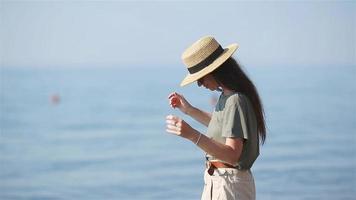 ung skön kvinna har roligt på tropisk stranden. Lycklig flicka bakgrund de blå himmel och turkos vatten i de hav video