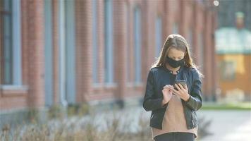 menina vestindo uma máscara em um fundo de um edifício moderno, video