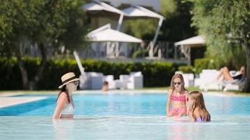 madre y dos hijos disfrutando de las vacaciones de verano en una piscina de lujo video