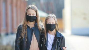 filles portant un masque sur fond d'un bâtiment moderne, video
