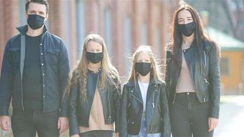 família vestindo uma máscara em um fundo de um edifício moderno, video