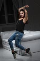 Happy brunette posing sitting on a sofa photo