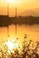 Sunset on the Lake in misty  with electricity lines in background photo