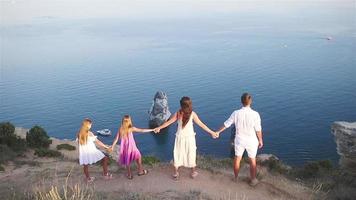 famille heureuse de quatre personnes marchant dans les montagnes au coucher du soleil video